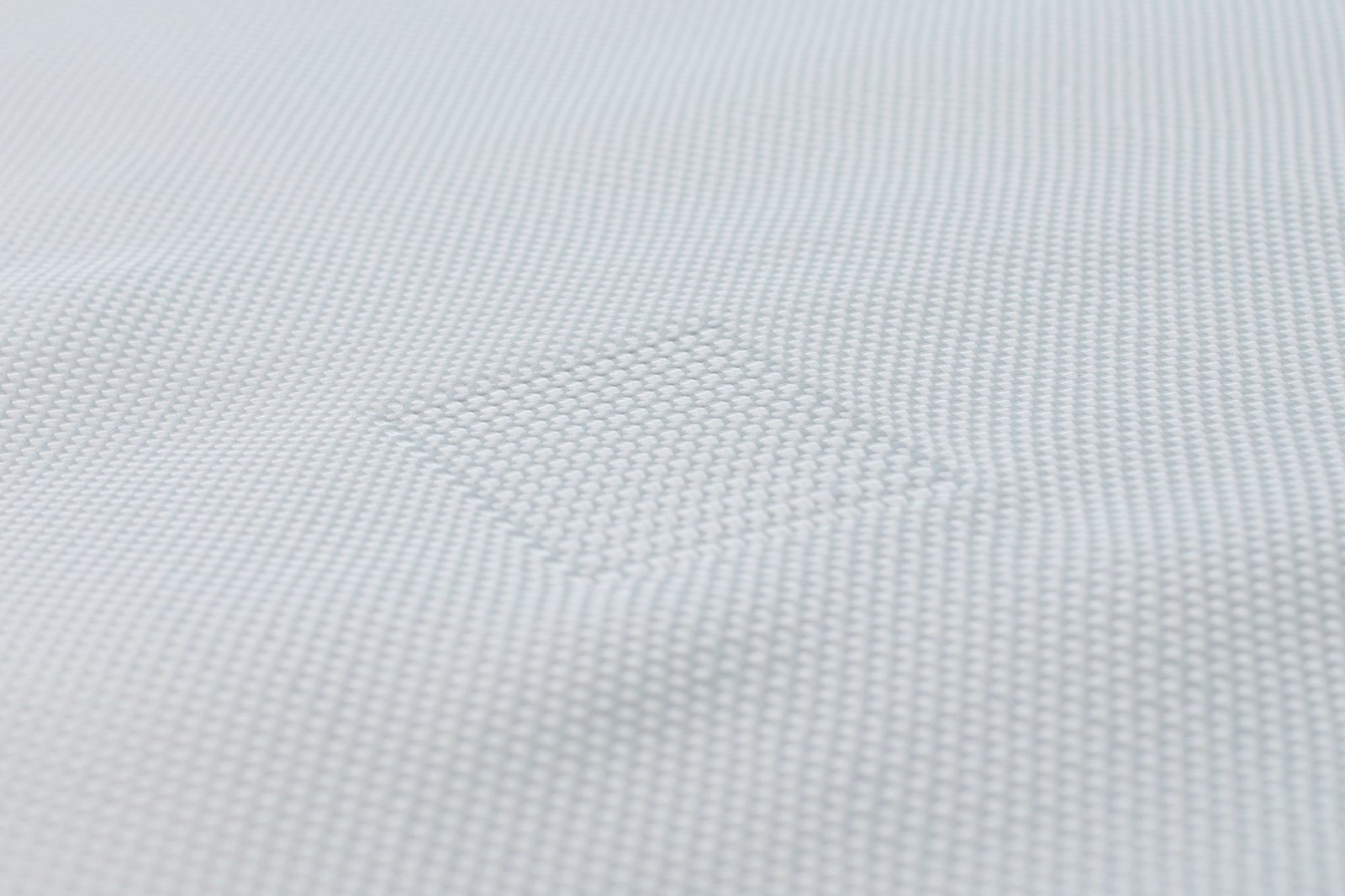 Close-up view of a textured, white Articulated Concrete Mattress, showcasing its woven fabric structure. The fabric features a unique pattern that implies strength and durability, essential for erosion control in civil engineering applications. This image highlights the materials used in creating a robust concrete mattress, designed to provide environmental protection and stability.